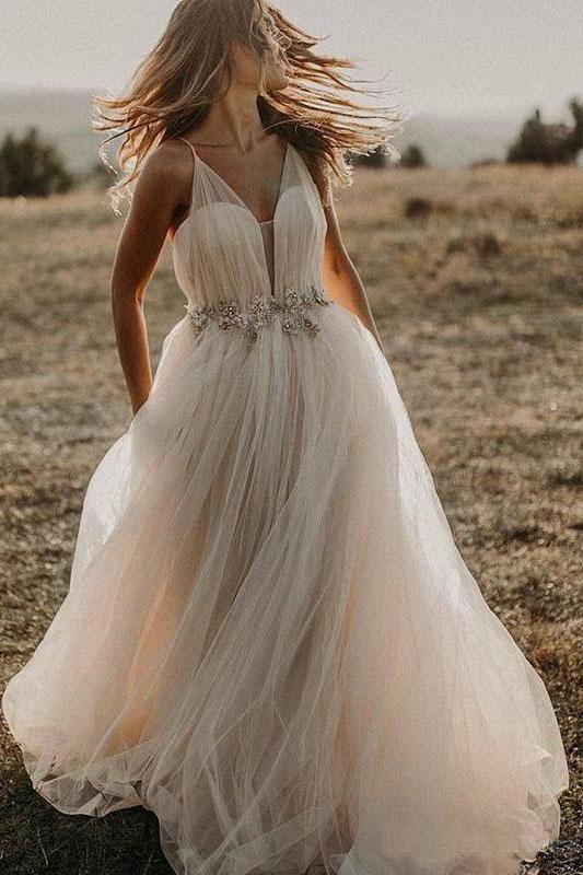 Vestido de novia bohemio playero con escote en V profundo y tirantes finos de tul.